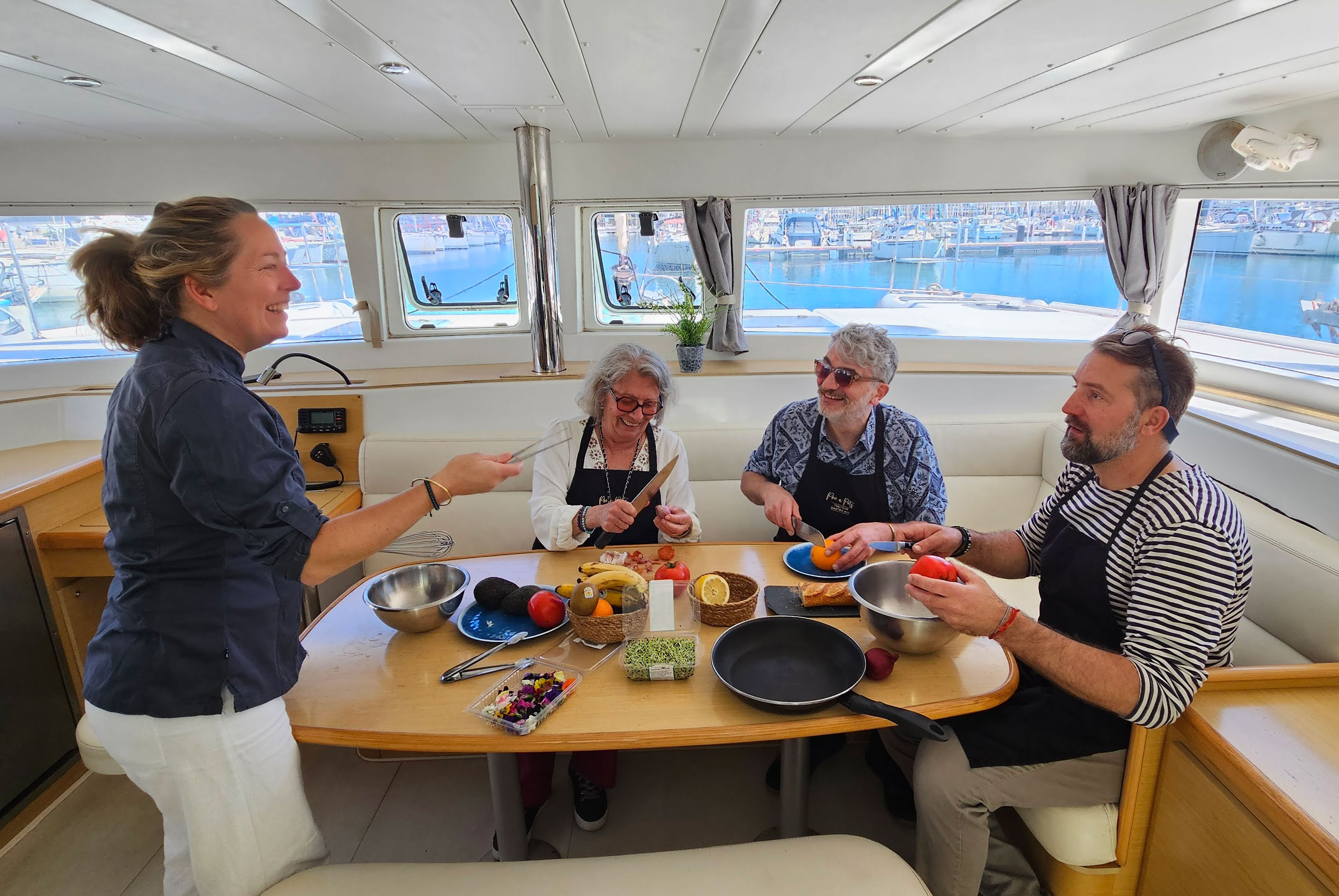 Guests cooking with a French chef aboard a private catamaran in Barcelona